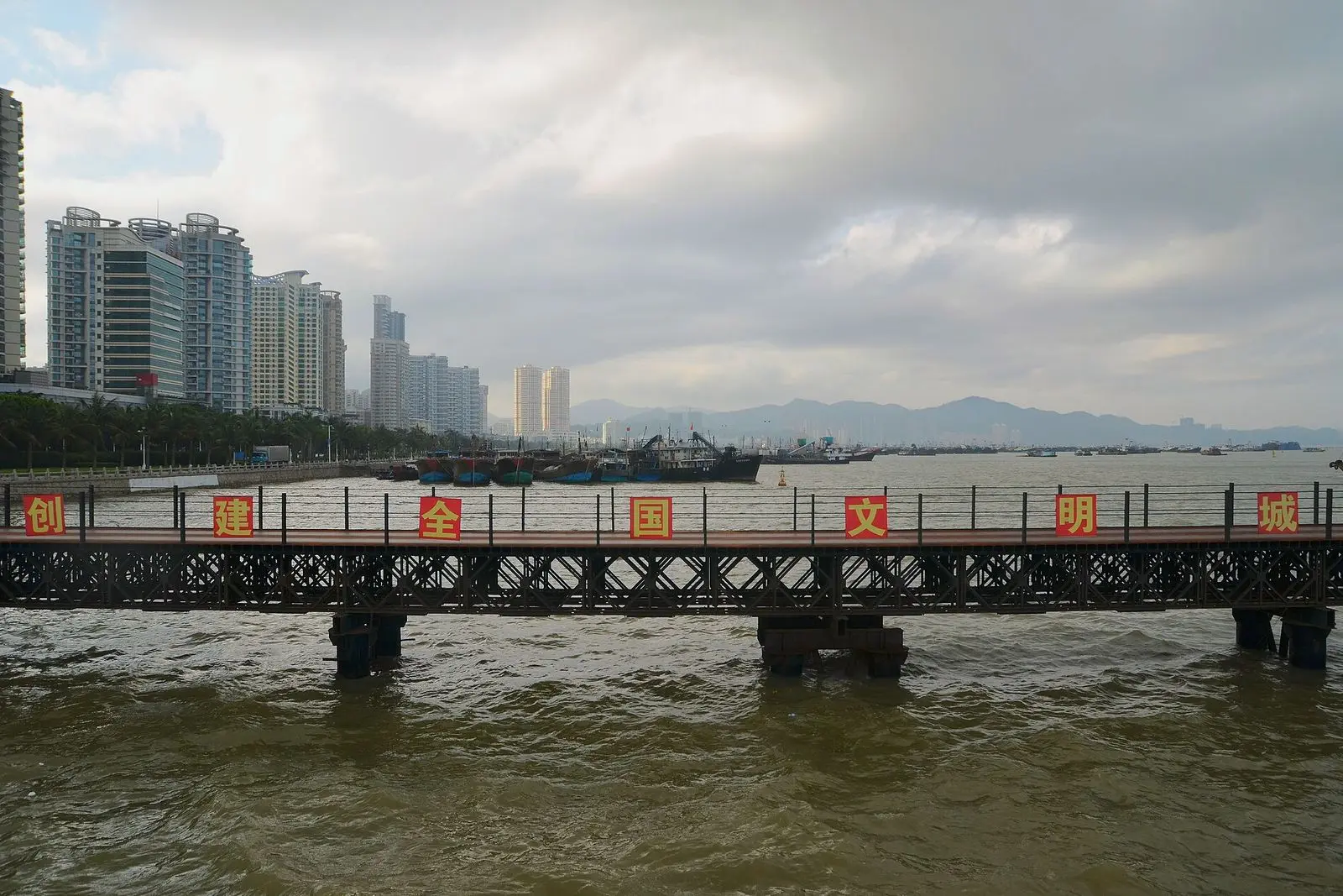 Xiangzhou harbour in Zhuhai on background. on foreground, a temporary metal bridge built for trucks aiming to build the futur Zhuhai Opera on Yeli Island.